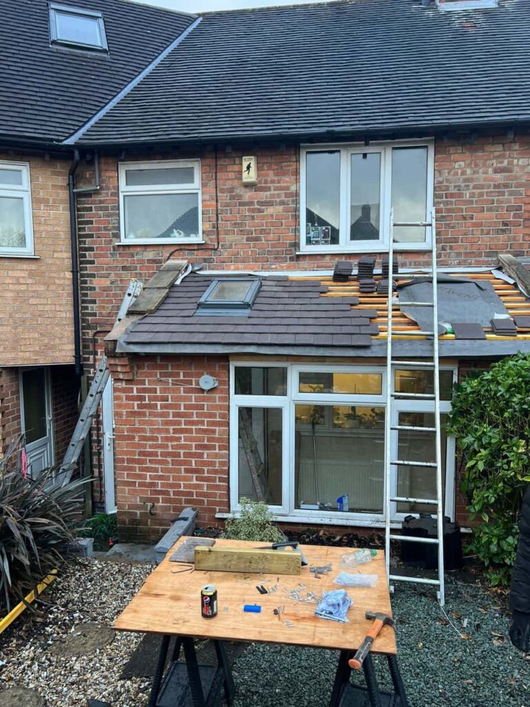 This is a photo of a roof extension that is having new roof tiles installed. This is a photo taken from the roof ridge looking down a tiled pitched roof on to a flat roof. Works carried out by Biggin Hill Roofing Repairs