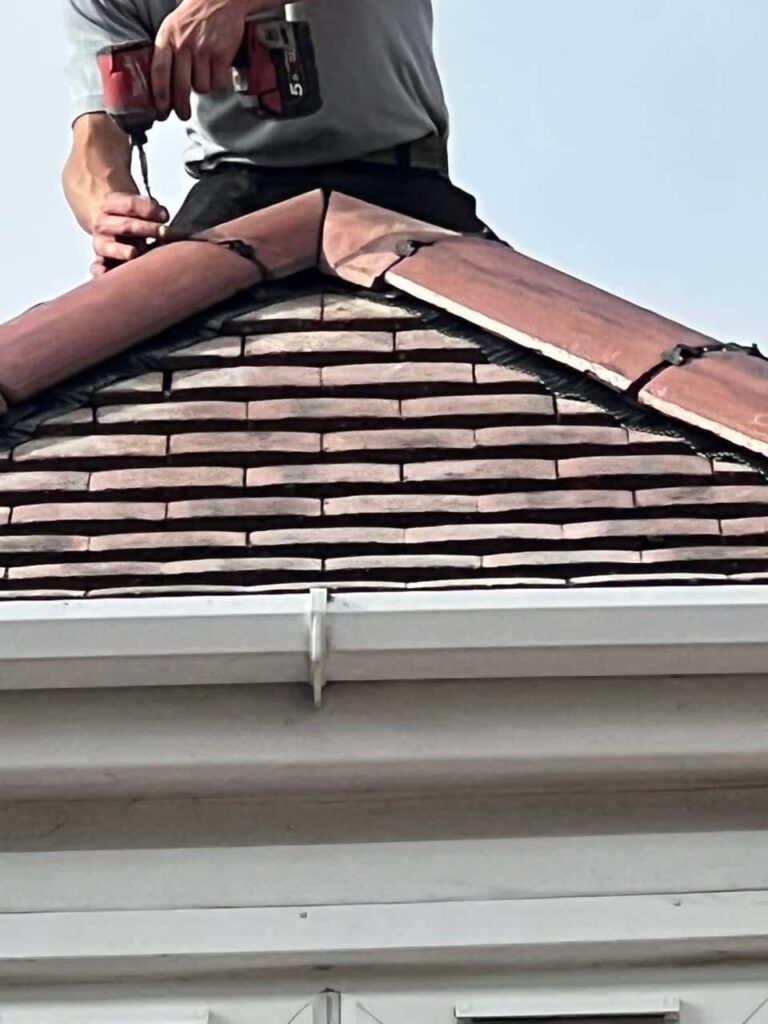 This is a photo of one of the operatives of Biggin Hill Roofing Repairs installing new ridge tiles